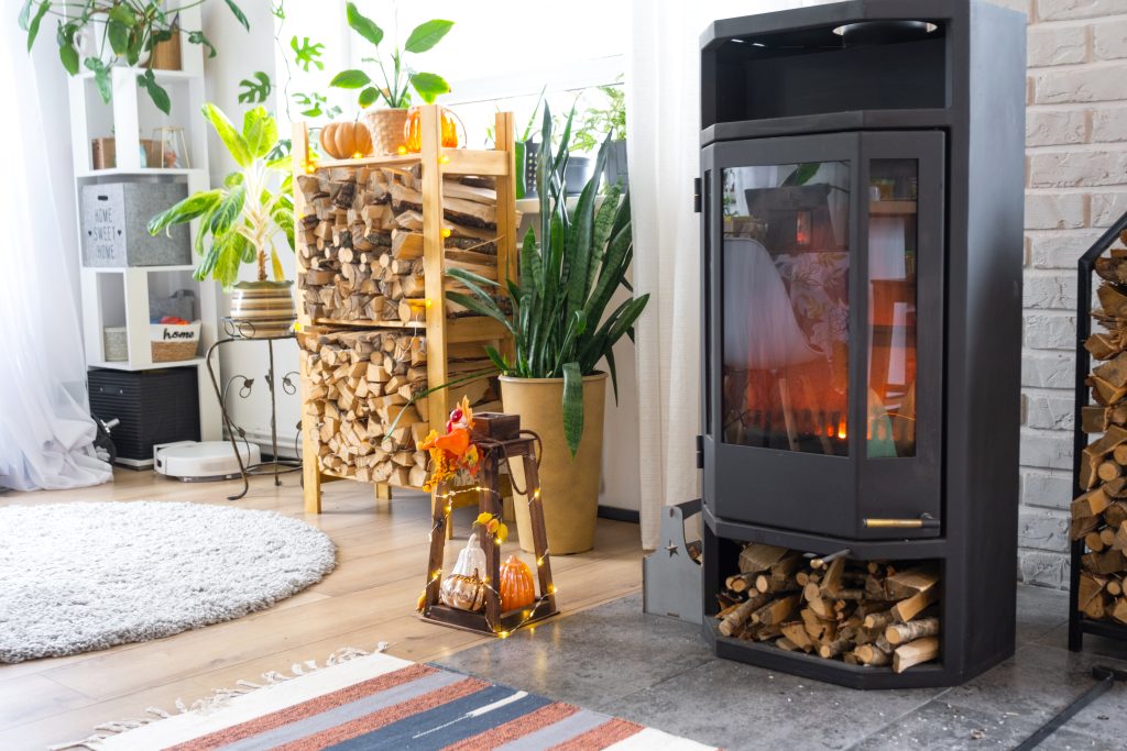 Gemütlicher Kaminofen im Wohnzimmer, spendet behagliche Wärme. Moderne Inneneinrichtung mit Fokus auf Komfort und Stil. Einladende Atmosphäre für entspannte Abende zu Hause, inspiriert von Stefan Thurau's Expertise in stilvoller Raumgestaltung.