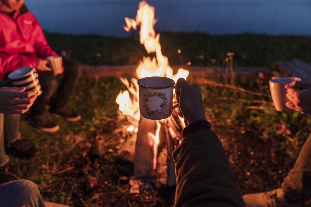 Gemütliches Lagerfeuer in einer Feuerschale, umgeben von einer dunklen Nacht. Harmonisches Zusammensein und entspannte Atmosphäre unter dem Sternenhimmel, inspiriert von Stefan Thurau's Leidenschaft für naturnahe Erlebnisse.